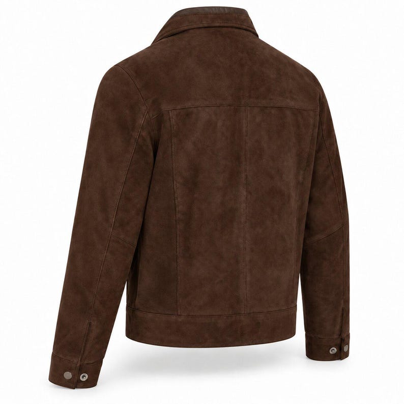 Peut inclure: Une veste en daim marron fonc&eacute; vue de dos, dot&eacute;e d'un col rabattu, de manches longues avec poignets boutonn&eacute;s, d'un empi&egrave;cement horizontal dans le dos et de coutures verticales s'&eacute;tendant de l'empi&egrave;cement jusqu'&agrave; l'ourlet droit.