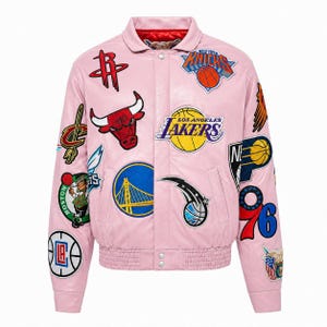 Peut inclure: Une veste style varsity rose clair ornée de divers logos d'équipes de la NBA brodés et d'écussons sur le thème du basket-ball sur le devant et les manches. La veste présente un col, une fermeture à boutons-pression et des bords-côtes.