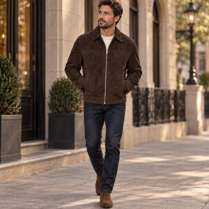 Peut inclure: Une veste en daim marron fonc&eacute; avec une fermeture &eacute;clair argent&eacute;e sur toute la longueur, un col classique et des manches longues, port&eacute;e sur une chemise blanche unie avec un jean bleu fonc&eacute; et des bottines en daim marron assorties.