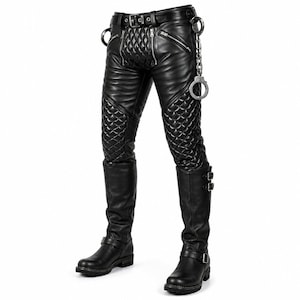 May include: Black leather pants featuring quilted panels on the thighs and crotch, multiple silver-tone zippers, a belt with a buckle, and a metal chain with attached handcuffs. The pants are paired with black leather boots with side buckles.