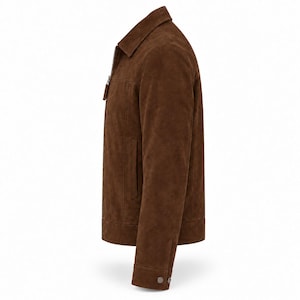 Peut inclure: Une veste en daim marron vue de profil. La veste pr&eacute;sente un col classique, une fermeture &eacute;clair int&eacute;grale sur le devant avec une tirette marron assortie, des manches longues avec des poignets boutonn&eacute;s et des poches fendues verticales.