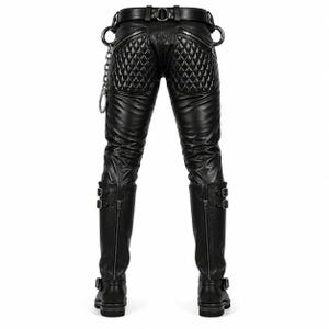 May include: Black leather pants featuring quilted panels on the back, a belt with metal loops, and a silver chain attachment. The pants are paired with tall black leather boots that have double buckle straps and vertical zippers on the back.