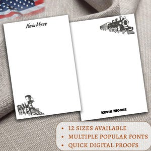May include: Two white notepads with a black train illustration and the name "Kevin Moore" printed on them. One notepad has the train in the upper right corner, the other in the lower left. The text "12 sizes available", "Multiple popular fonts", and "Quick digital proofs" is also visible.