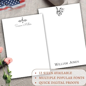 May include: Two white notepads with personalized names, "Susan Miller" and "William Jones", and a musical note design. The notepads are on a beige fabric background. The text below the notepads reads "12 sizes available", "Multiple popular fonts", and "Quick digital proofs".