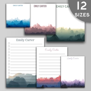 May include: A set of 12 printable stationery note cards featuring a watercolor mountain range design in various colors. The cards are personalized with the name "Emily Carter".