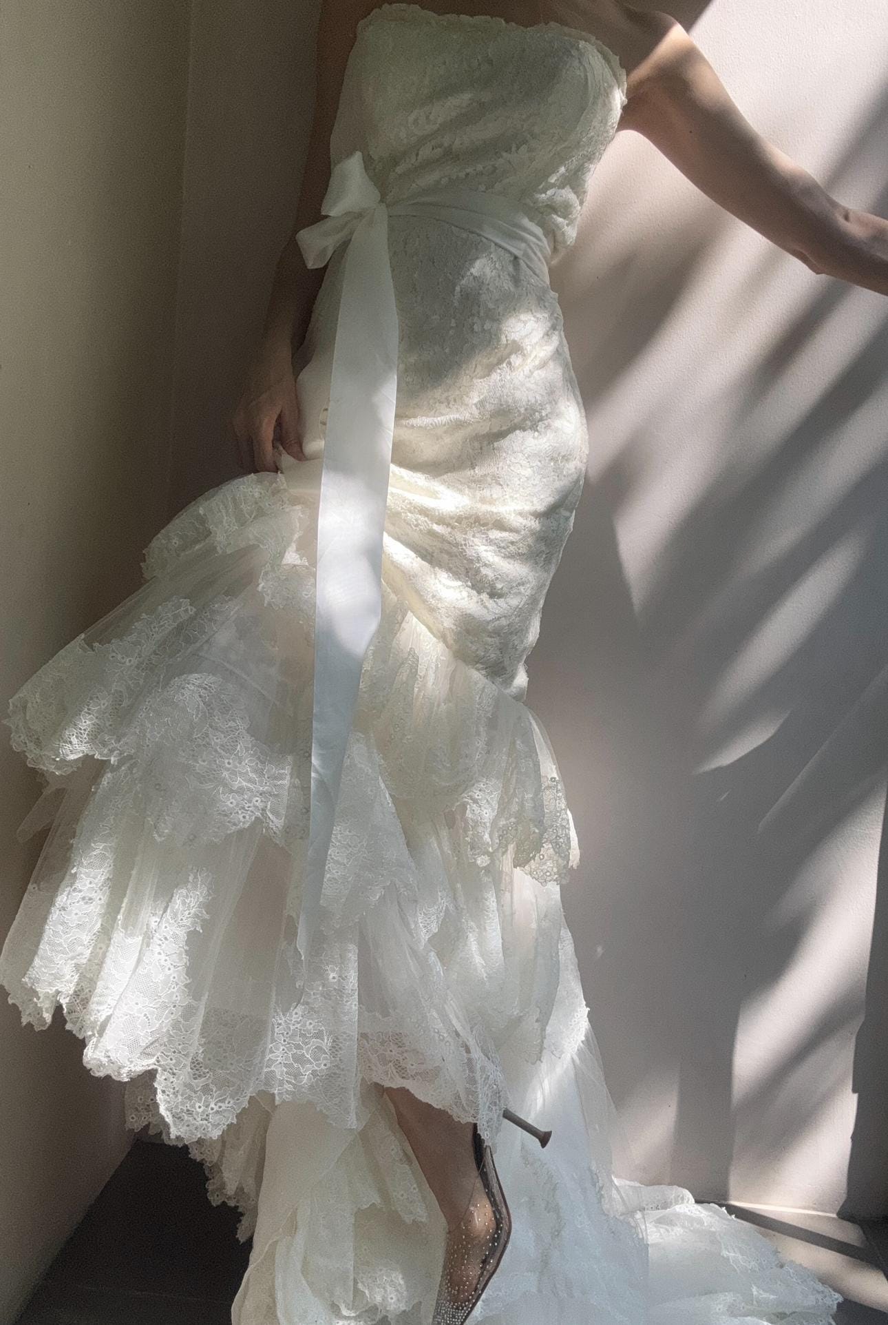 White lace strapless bandeau wedding dress with a mermaid silhouette and a lace bottom and a train