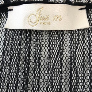 May include: Close-up of a black lace garment with a white label. The label features gold lettering that reads "Just m PARIS". The top edge has a black trim with silver accents.