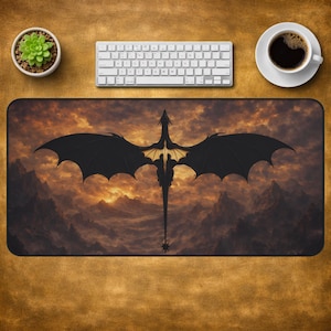 Peut inclure: Un tapis de bureau rectangulaire présentant la silhouette d'un grand dragon noir aux ailes déployées. Le dragon est centré sur un ciel de coucher de soleil nuageux et dramatique au-dessus d'une chaîne de montagnes. Le tapis a une bordure sombre.