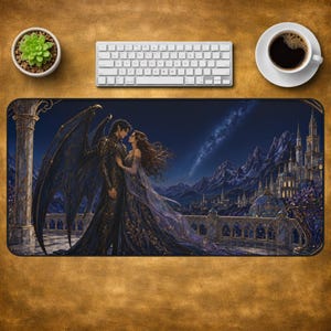 Peut inclure: Un tapis de bureau rectangulaire présentant une illustration fantastique d'une silhouette ailée en armure sombre et d'une personne en robe bleue fluide sur un balcon. Le fond montre un château, des montagnes et un ciel nocturne étoilé.