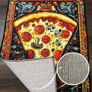 May include: A colorful rug with a large slice of pizza in the center. The rug has a black border with a gold trim. The pizza has pepperoni, mushrooms, and cheese. The rug has a non-slip rubber backing.