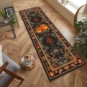 May include: A long, rectangular black rug with a Halloween theme. The rug features orange pumpkins, floral patterns, and spiderwebs. The border is a mix of orange, brown, and gold. The rug is placed on a wooden floor.