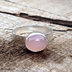 Calcedonia ovalada rosa suave y romántica en plata de ley con banda de anillo de plata de ley martillada
