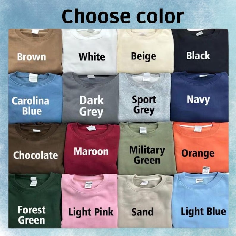 以下が含まれることがあります： 茶色、白、ベージュ、黒、カロライナブルー、ダークグレー、スポーツグレー、ネイビー、チョコレート、マルーン、ミリタリーグリーン、オレンジ、フォレストグリーン、ライトピンク、サンド、ライトブルーなど、さまざまな色のクルーネックのスウェットシャツのグリッド。「Choose color」の文字が上にあります。