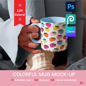May include: A white mug with a light blue handle and interior, covered in colorful strawberry illustrations. The mug is held by a person wearing a light blue sweater. Text on the image reads "12X Colors!" and "COLORFUL MUG MOCK-UP".