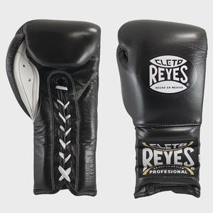 Puede incluir: Un par de guantes de boxeo de cuero negro con cordones blancos y la marca "CLETD REYES" impresa. Los guantes, hechos en México, están diseñados para uso profesional.