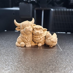 Op de afbeelding: Drie lichtbruine dierenbeeldjes: een Schotse Hooglander met hoorns, een schaap en een kip. De figuren zijn gedetailleerd en lijken van hout of een vergelijkbaar materiaal te zijn gemaakt. Ze zijn samen geplaatst, wat een boerderijtafereel suggereert.