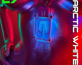 May include: A rectangular silver-toned pendant on a ball chain, illuminated with blue light. The pendant features the text MARTINET MARGO 6545456507 A+ LEVEL 07 ACCESS. The overall scene is bathed in vibrant red and blue neon lighting effects.