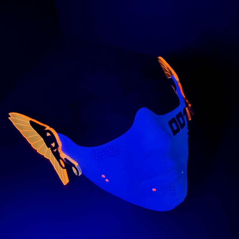 May include: A blue face mask with orange accents and the word "001" printed on the side. The mask is made of a breathable material and has a unique design.