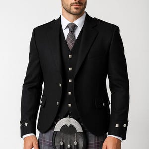 May include: A black formal jacket, waistcoat, and tie. The jacket has silver square buttons and cuff details. The waistcoat has matching buttons. The outfit is worn with a traditional Scottish kilt and sporran.