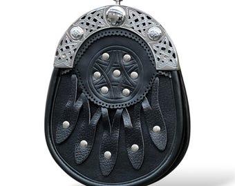 Könnte beinhalten: Ein schwarzer Ledersporran mit einem silbernen keltischen Knotendesign und einer Klappe mit fünf Zacken. Der Sporran hat eine silberne Schnalle und eine silberne Kette.