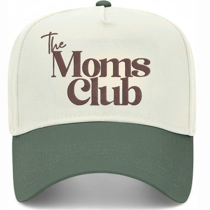 Peut inclure: Casquette de baseball avec une couronne cr&egrave;me et une visi&egrave;re verte. Le texte "The Moms Club" est imprim&eacute; en marron sur le devant. La casquette a une visi&egrave;re incurv&eacute;e et un bouton sur le dessus.