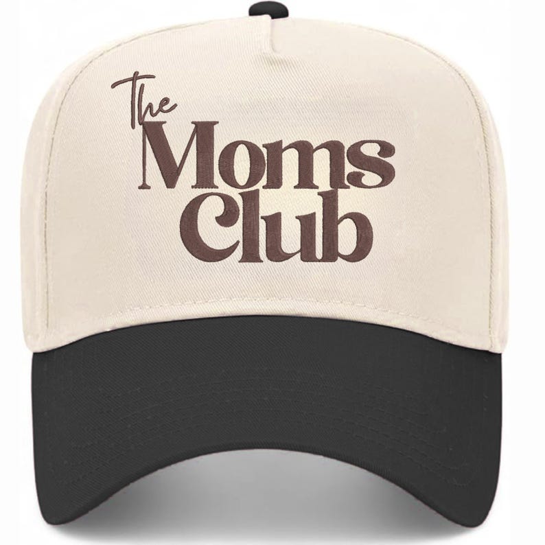 Peut inclure: Casquette de baseball avec une couronne cr&egrave;me et une visi&egrave;re noire. Le texte "The Moms Club" est inscrit en lettres marron sur le devant. La casquette a une visi&egrave;re incurv&eacute;e et un bouton sur le dessus.