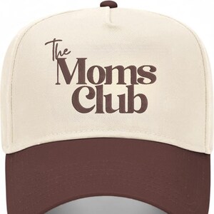 Peut inclure: Casquette de baseball beige et marron avec l'inscription "The Moms Club" en marron. La casquette a une visi&egrave;re incurv&eacute;e et un bouton sur le dessus. Un chapeau de style classique, adapt&eacute; aux tenues d&eacute;contract&eacute;es.