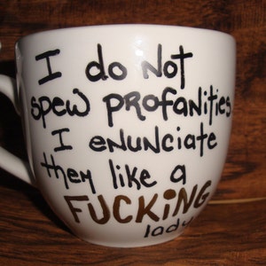 May include: White ceramic mug with black handwritten text: "I do Not spew profanities I enunciate them like a FUCKING lady."