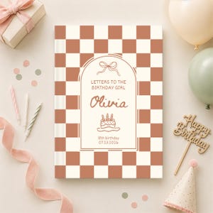 Könnte beinhalten: Ein rechteckiges Buch mit einem terrakottafarbenen und weißen Schachbrettmuster auf dem Einband. In der Mitte befindet sich ein Bogenrahmen mit einer Schleife, dem Text "LETTERS TO THE BIRTHDAY GIRL", dem Namen "Olivia", einem Kuchen und "18th birthday 07.23.2026".
