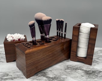May include: A set of three wooden organisers for makeup brushes, cotton buds, and cotton rounds. The organisers are made of dark wood and have a sleek, modern design.