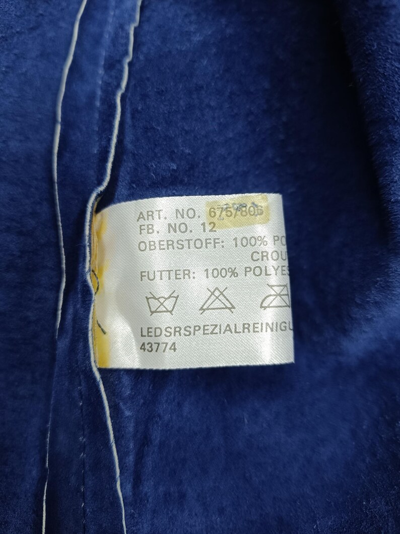 Peut inclure: Gros plan sur un tissu bleu fonc&eacute; avec une &eacute;tiquette blanche. L'&eacute;tiquette contient du texte, dont 'ART. NO. 6757806', 'FB. NO. 12', et '43774'. Le tissu semble doux.