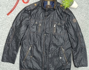 Peut inclure: Une veste noire à texture froissée dotée d'un col montant avec une doublure intérieure marron, une fermeture éclair frontale avec boutons-pression, deux poches poitrine zippées, deux poches inférieures zippées avec boutons-pression et des épaulettes.