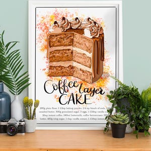 Könnte beinhalten: Eine Aquarell-Illustration eines Kaffee-Schichtkuchens mit braunem und weißem Frosting. Der Kuchen ist in der Mitte durchgeschnitten, um die Schichten zu zeigen. Der Text "Coffee Layer Cake" ist in schwarzer, kursiv geschriebener Schrift unter dem Kuchen zu sehen. Das Rezept für den Kuchen ist unter dem Text aufgelistet. Das Rezept enthält Zutaten wie Mehl, Backpulver, Natron, Butter, Zucker, Eier, Vanilleextrakt, Instantkaffee, Buttermilch und Puderzucker.