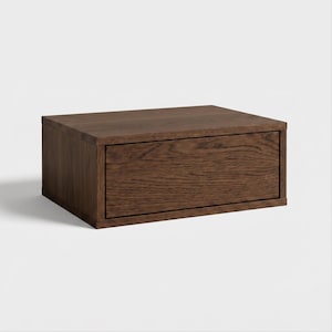 May include: A rectangular storage box crafted from dark brown wood with a visible natural grain pattern. The box features a single front-facing drawer panel that is flush with the frame, creating a clean and simple box-like structure.