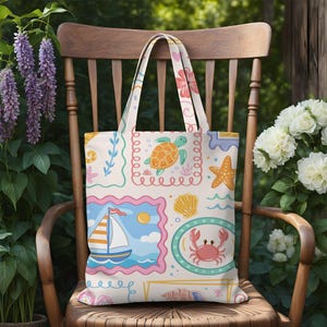May include: A cream-colored tote bag featuring a repeating pattern of colorful illustrations including a sea turtle, a sailboat, a crab, a starfish, and various seashells framed in scalloped borders with soft pink, blue, and yellow accents.
