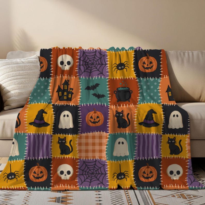 Op de afbeelding: Een fleece deken met een patchwork ontwerp van Halloween iconen, waaronder oranje pompoenen, witte schedels, zwarte katten, geesten, spinnen, webben, vleermuizen, een spookhuis en een zwarte ketel, gescheiden door witte stiksel-achtige lijnen.