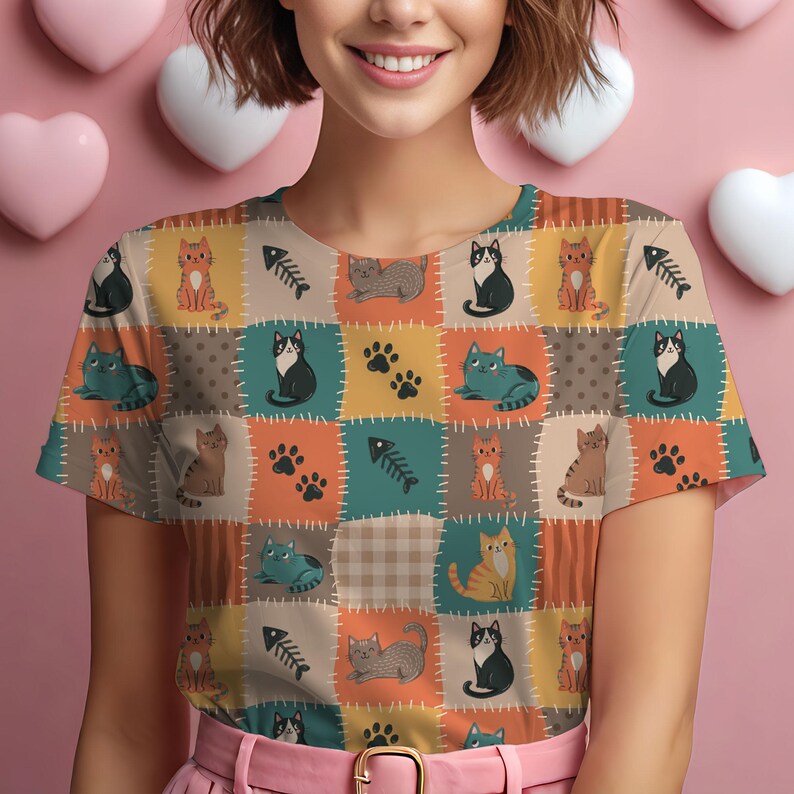 May include: A short-sleeved t-shirt featuring a patchwork-style print of various cats, fish bones, and paw prints in shades of orange, teal, brown, and cream. The design includes stitched-look borders between the colorful rectangular sections.