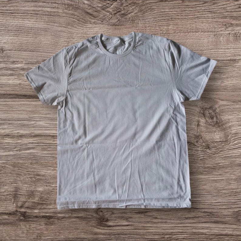 Puede incluir: Una camiseta lisa de color gris claro con mangas cortas y cuello redondo.