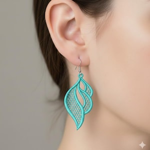 May include: A close-up of a turquoise earring with a leaf-like design. The earring is made of a delicate, openwork material, with a curved shape and a small hook for the ear. The earring is a vibrant shade of turquoise.
