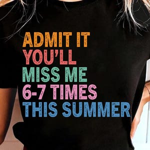 Peut inclure: T-shirt noir avec le texte "ADMETTEZ-LE, VOUS ME MANQUEREZ 6-7 FOIS CET ÉTÉ" en orange, rouge, vert, rose et bleu. Le t-shirt est à col rond et est porté.