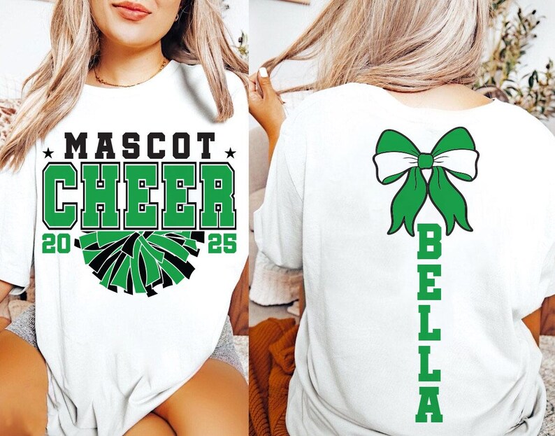 May include: White t-shirt with green and black cheerleading design on the front and a green bow with the name "BELLA" on the back. The text on the front says "MASCOT CHEER 20 25".