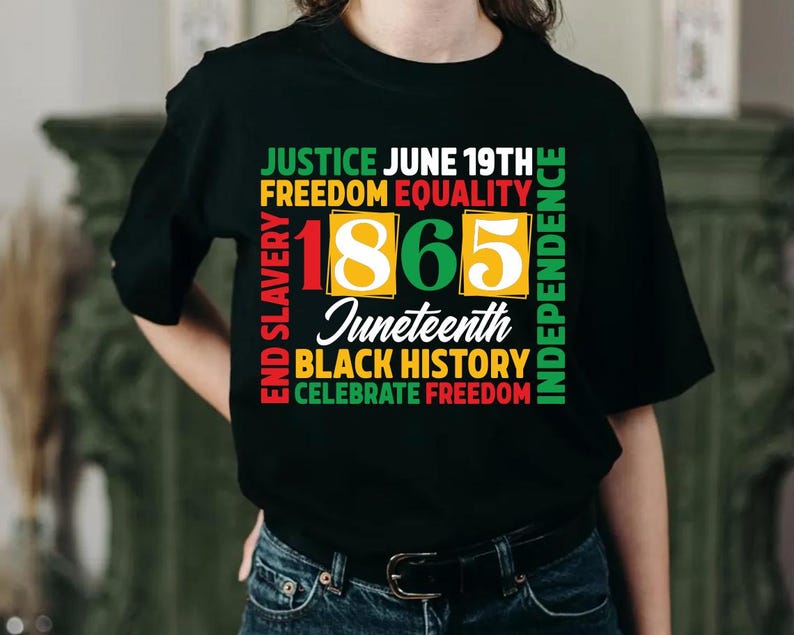 May include: Black t-shirt with a colorful graphic design celebrating Juneteenth. The design includes the text "Justice, Freedom, Equality, Independence, End Slavery, Black History, Celebrate Freedom" and the year "1865".