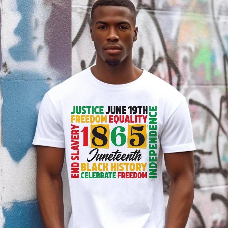 May include: White t-shirt with a colorful graphic design. The design includes the words "Justice," "Freedom," "Equality," "1865," "Juneteenth," "Black History," and "Celebrate Freedom." The shirt is worn by a person in front of a graffiti wall.