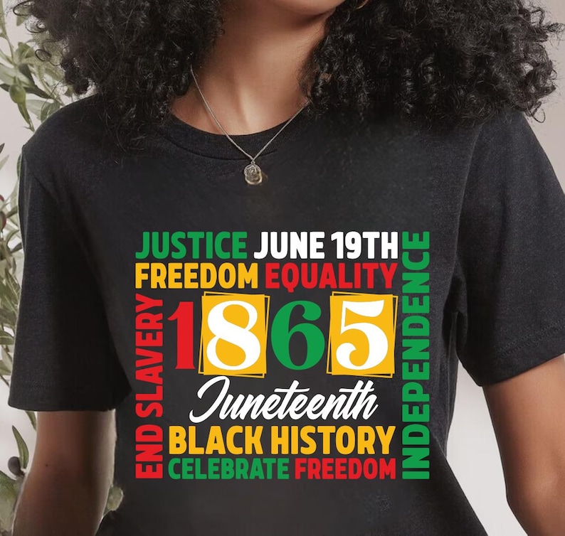 May include: Black t-shirt with a colorful graphic design. The design includes the words "Justice," "Freedom," "Equality," "1865," "Juneteenth," "Black History," and "Celebrate Freedom."