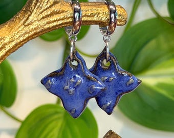 Pendientes de aro con dije de flor de cerámica azul hechos a mano, latón chapado en platino, joyería artesanal llamativa.