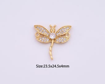 Op de afbeelding: Goudkleurige libellenbedel met heldere kristallen accenten. De bedel heeft twee lussen om aan sieraden te bevestigen. Maat: 23,5x24,5x4mm.