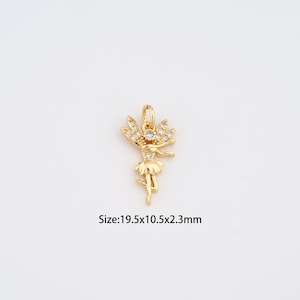 May include: A gold-colored pendant in the shape of a ballerina, adorned with clear crystals. The pendant measures 19.5mm x 10.5mm x 2.3mm. The ballerina is depicted with outstretched arms and a tutu. The pendant has a loop for attaching to a chain.