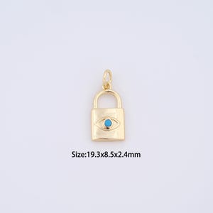 May include: Gold-colored padlock charm with a turquoise eye design. The charm measures 19.3mm x 8.5mm x 2.4mm. The charm has a loop at the top for attaching to a necklace or bracelet. The charm is on a white background.