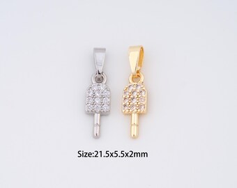 May include: Two pendant charms, one silver-toned and one gold-toned, each shaped like a popsicle. The silver charm is encrusted with clear crystals, while the gold charm has smaller, more densely packed crystals. The size is 21.5x5.5x2mm.