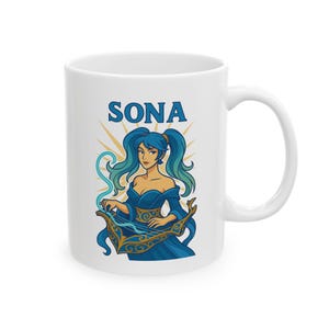 May include: White ceramic mug featuring a blue-haired woman playing a harp. The word "SONA" is printed above the illustration in blue. The woman is wearing a blue dress with gold accents. The mug has a white handle.